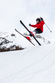 Male kid performs a high jump with the ski. Winter season, red jacket. Valle d'Aosta, Italy, Europe. - PhotoDune Item for Sale