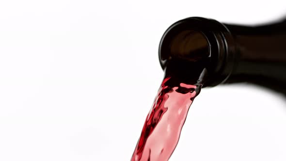 Super Slow Motion Detail Shot of Pouring Red Wine From Bottle Isolated on White at 1000Fps