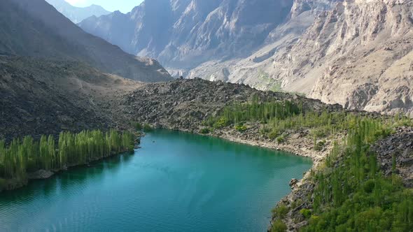 aerial drone of a unique glacier blue lake called Upper Kachura Lake, surrounded by a green forest i