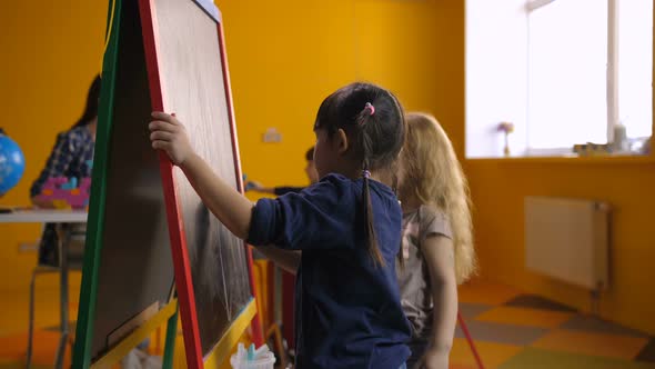 Cheerful Multi Ethnic Girls Drawing on Chalkboard