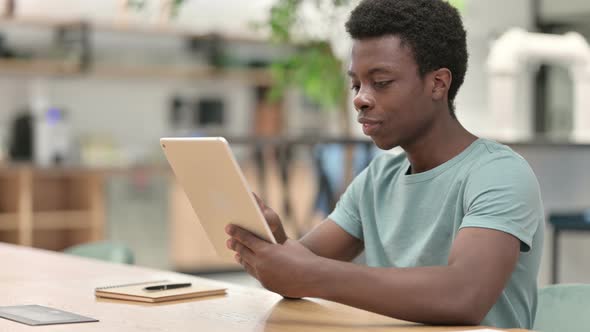 Serious Young African Man Using Tablet