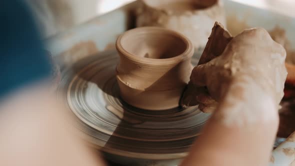 Hands of Woman Working on a Pottery Wheel. Creating a Ceramic Pot. Closeup. Arts Lessons and Pottery