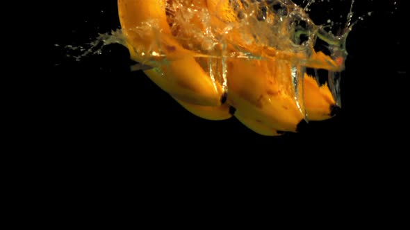 Super Slow Motion Fresh Bananas Fall Into the Water with Splashes