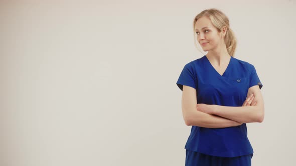 Copy Space White Background Female Doctor Surgeon Looking Aside and Crossing Her Arms