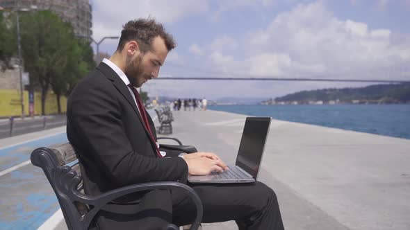 Businessman focused on his work working on his laptop. Slow motion.