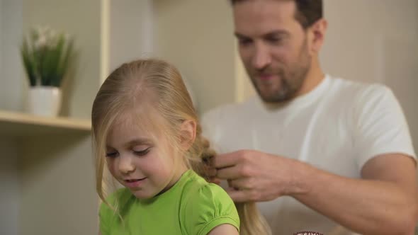 Happy Single Father Braiding Daughter's Hair, Taking Care of Beloved Little Girl