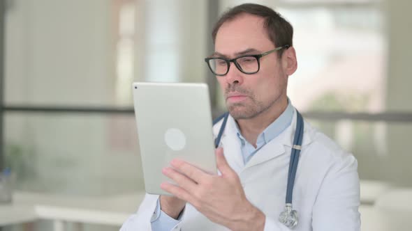 Middle Aged Doctor Using Digital Tablet