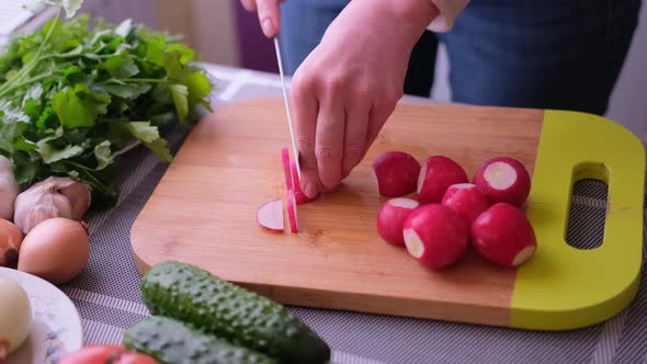 Closeup of Woman Slicing Radish on Wooden Cutting Board  Preparing Ingredient for Meal