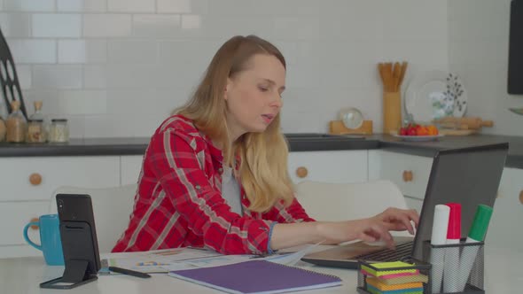 Multitasking Freelance Woman Speaking on Smartphone Loudspeaker During Work