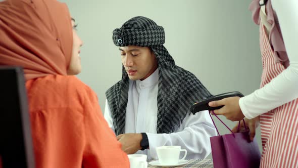 Asian Muslim Man Using Mobile Phone Payment 