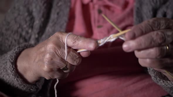 Elderly lady's hands knitting close up slow panning shot