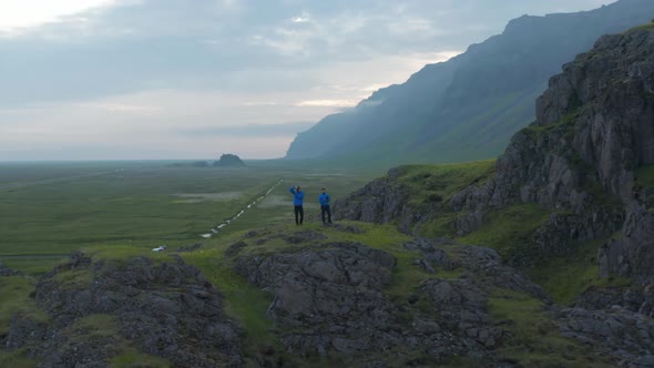 Drone View Orbit Around Two Men Tourist Standing Top Peak Taking Picture Looking Amazing Foggy