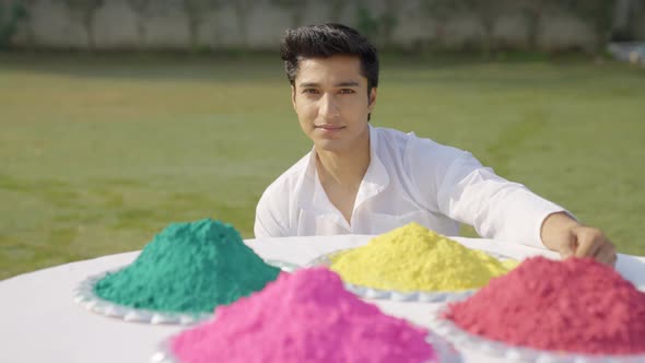 Happy Indian man looking at the Holi colors