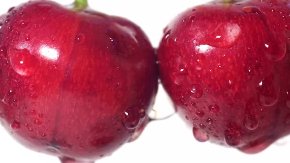 Red Cherry Berries in Water Drops on a White Background