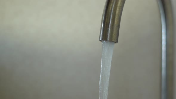 Water Flows From the Kitchen Faucet Closeup