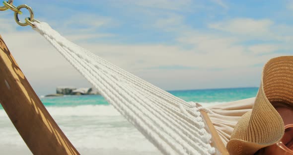 Side view of Caucasian woman relaxing in a hammock at beach 4k