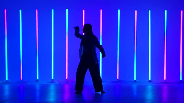 Young Woman Dancer Dancing Contemporary in the Studio Against the Background of Multicolored Neon