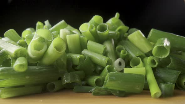 Green Onion Stalks Cut Into Pieces on a Wooden Board