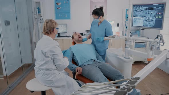 Dentist and Assistant Doing Consultation with Dental Tools