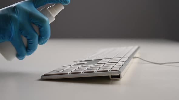 Closeup of a Woman Disinfects a White Computer Keyboard