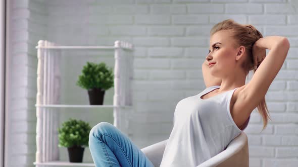 Happiness Young Girl Stretching Sitting in Comfy Armchair