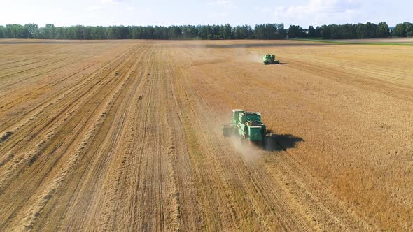 Aerial Drone Shot of a Combine Harvester Working in a Field at Sunset