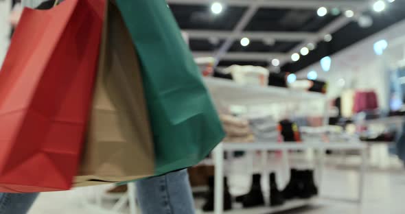 Close Up of Young Woman Walks with Colorful Shopping Bags Around a Shopping Mall