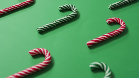 Red and green striped candy canes on green background