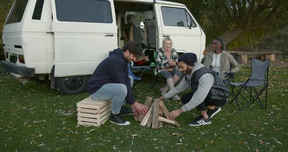 Four Friends Near a Camper Van By the River