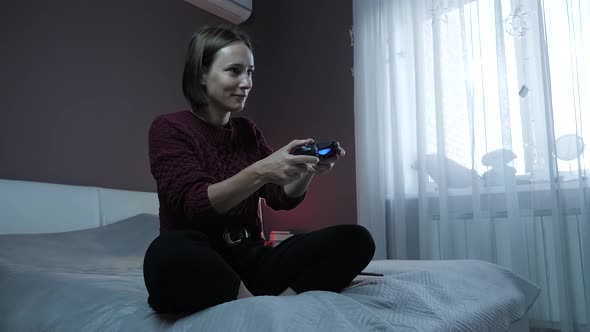 Girl playing in video games on digital console using wireless joystick
