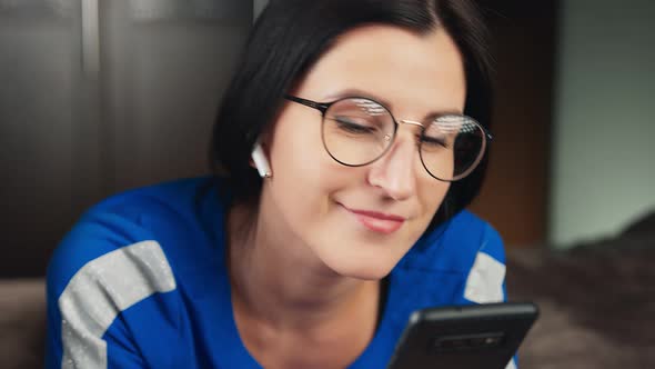 Closeup Face of Female in Wireless Earphone Lying on Bed Listen Music