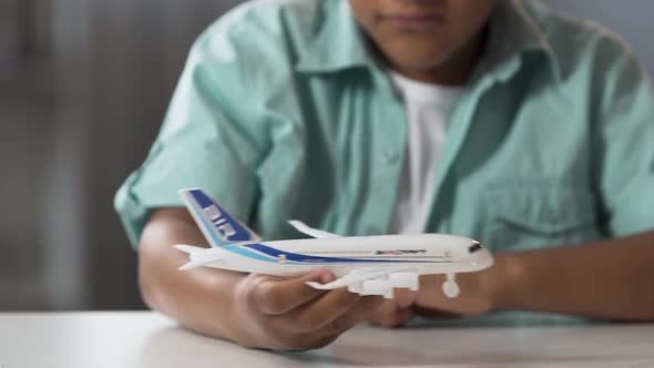 Biracial Male Child Playing with Toy Airplane in Free Time, Childhood Dream