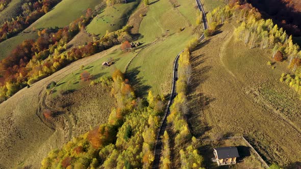 Flying Over Epic Mountain Road in the Autumn. Aerial View of Hills and Pasture