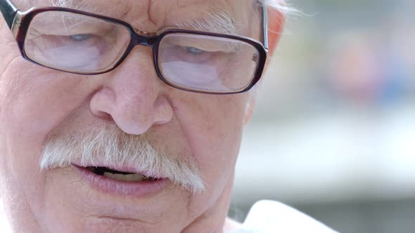 An Old Grandfather with a Gray Mustache and Glasses He Angrily Speaks to the Camera