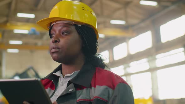 Female Factory Manager Using Digital Tablet