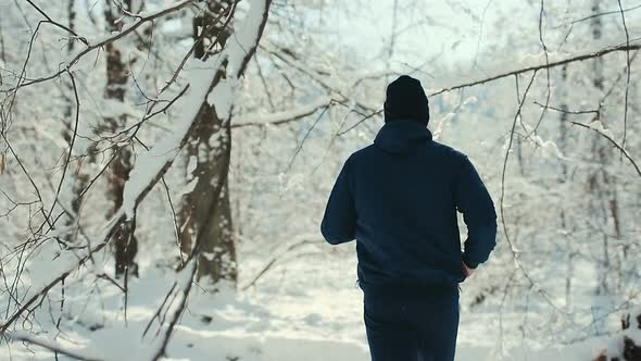 Young Sportsman Running Through Snowy Forrest