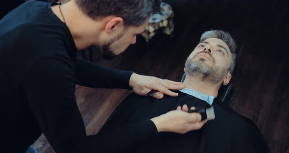 Man is Shaved Off His Beard the Client Lies on the Chair