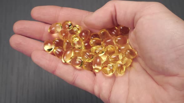 Omega-3 capsules in hand close-up 