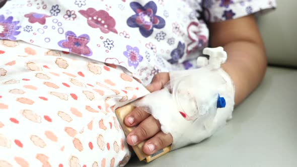 Baby Hand with Bandage Giving Saline on Bed