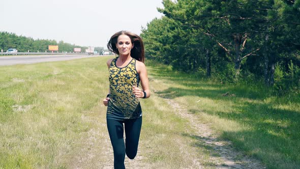 CU Portrait Young Girl Goes in for Sports in the Morning Runs Along a Pine Forest and Trails