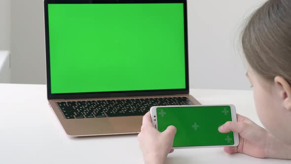 Schoolgirl Playing Game on Green Screen Phone During Online Lesson at Home