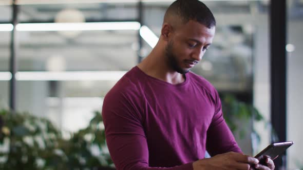 Mixed race businessman sitting using a digital tablet in office