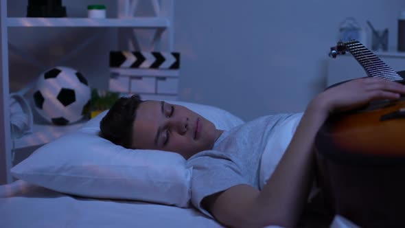 Teenager Falling Asleep With Guitar, Dreaming to Become Famous, Promising Boy