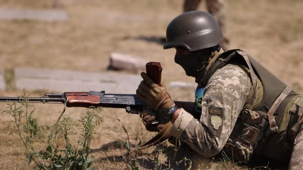 In Green Uniform Vest Military Man Unloads Machine Gun Soldier Lies with Gun Army War Concept