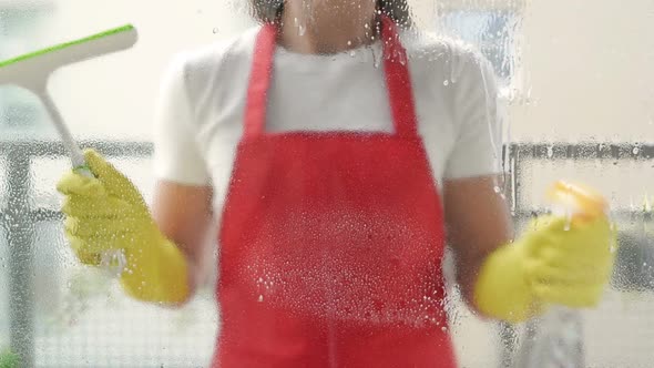 Cleaning Service Worker or Housewife Washes the Windows Using Detergent and Scraper for Cleaning