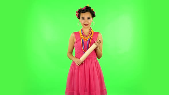 Girl with a Rolling Pin in Her Hands Seductively Looks at the Camera. Green Screen