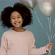 Cheerful little girl at her birthday party. Female child holding a lot of balloons - VideoHive Item for Sale