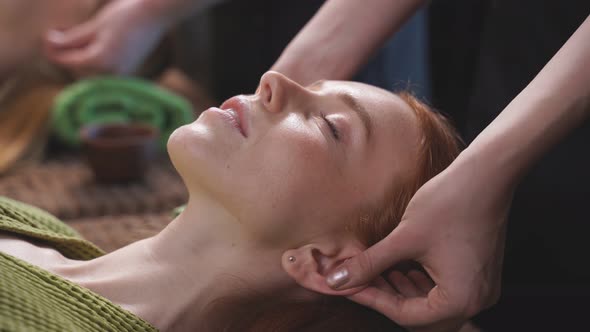 The Cosmetologist Massages a Woman's Face Relieves Muscle Tension Conducts Spa Treatments