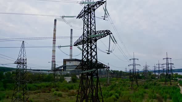 Electricity pylons and high-voltage power lines on the green grass. Power plant.