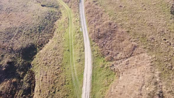 Aerial view of country hills at sunset in autumn season. Beautiful rural scene with dead nature, ear